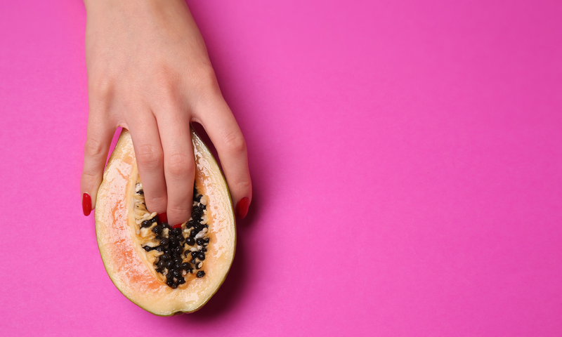 Hand holding half a papaya.