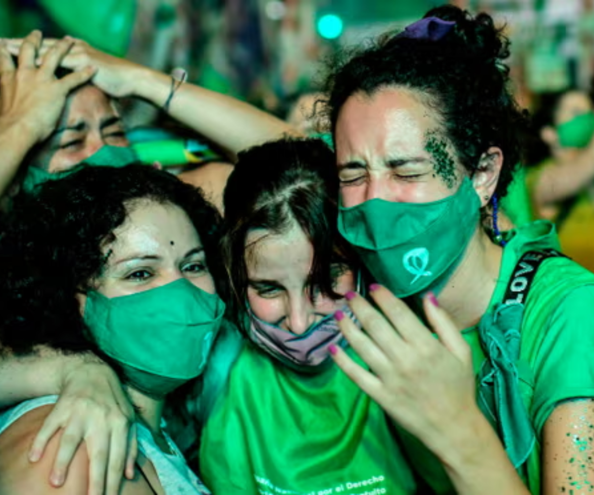 Women wearing green scarves celebrate in Argentina, symbolizing the feminist movement's fight for abortion rights and choice.