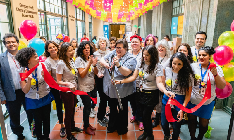 Bookshop team at LA LIBRERÍA's opening, cutting ribbon among balloons.